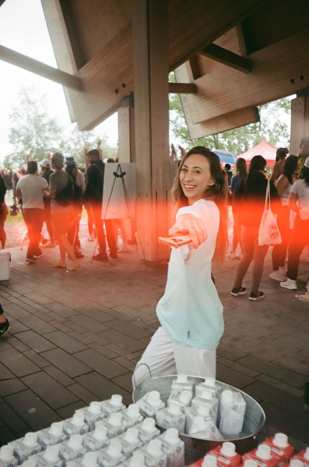 Marina Topolnytska smiling and reaching toward the camera at an outdoor event